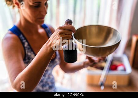 Woman playing brass bowl at studio Stock Photo