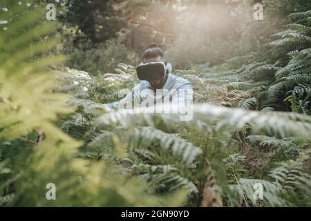 Man using virtual reality headset while exploring forest Stock Photo