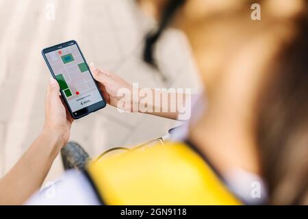 Female delivery person checking direction through smart phone Stock Photo