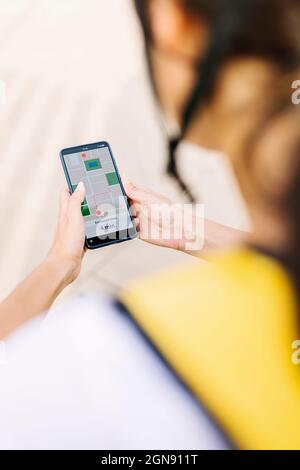 Female delivery person checking map on mobile phone Stock Photo