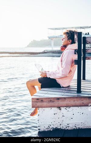 Young man relaxing on pier during weekend Stock Photo