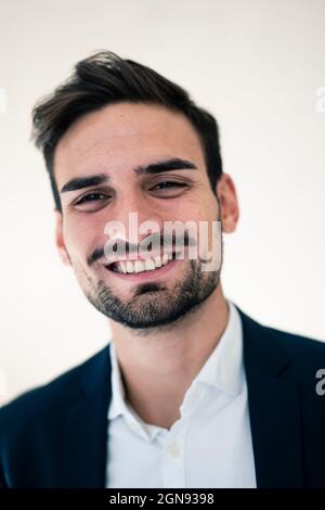 Happy young businessman with hair stubble in office Stock Photo