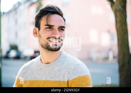 Handsome young man with hair stubble at park Stock Photo