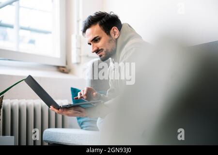 Young businessman using laptop while sitting in office Stock Photo