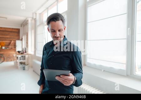 Smiling businessman showing car key in office Stock Photo