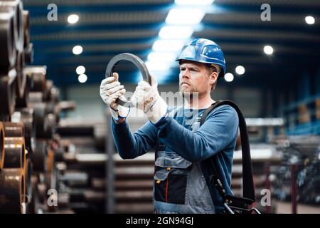 Male engineer checking circle shape equipment in factory Stock Photo