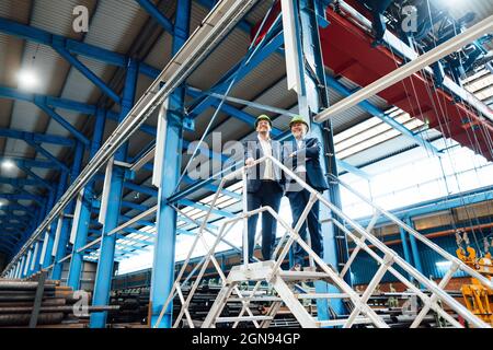 Male inspector checking circle shape steel equipment in warehouse Stock Photo