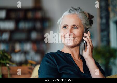 Smiling female cafe owner wearing apron in coffee shop Stock Photo