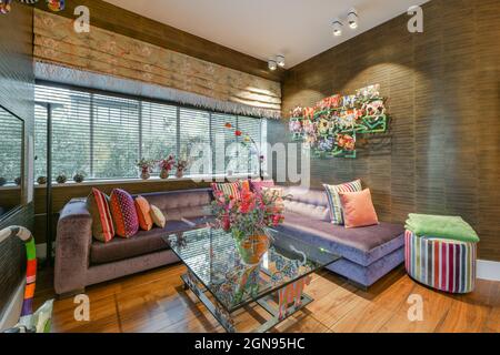 Comfortable sofa and glass table placed near wide windows Stock Photo