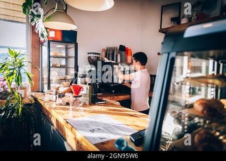 Female barista making coffee while working in cafe Stock Photo