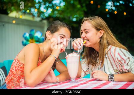 Backyard portrait of friends laughing and drinking together Stock Photo