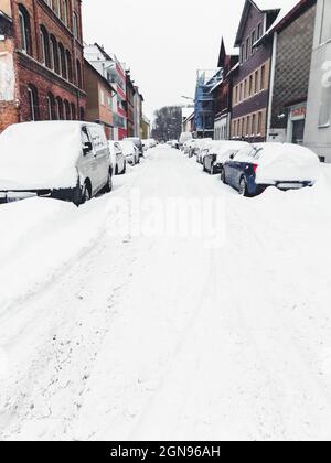 Winter landscape in the city of Braunschweig, Germany. Snow covered street and cars. Winter season with heavy snowfall Stock Photo