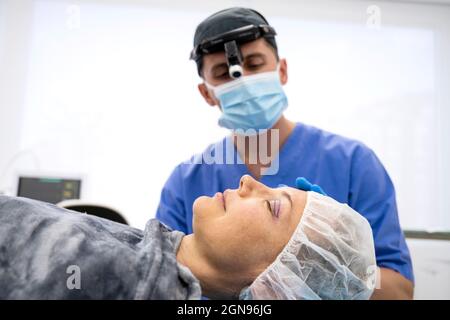 Female patient lying on a stretcher in an operating room Stock Photo