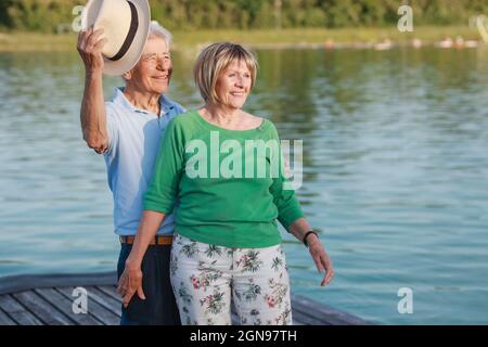 Smiling senior couple standing together on jetty Stock Photo