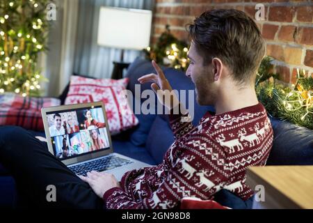 Man talking with family through video conference at home Stock Photo