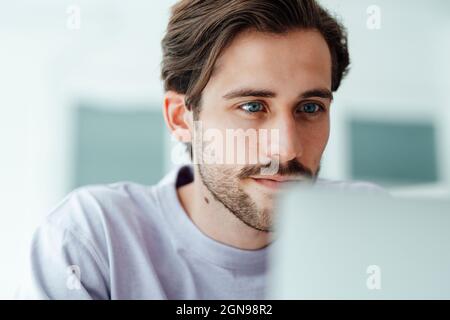 Young man using laptop at home Stock Photo