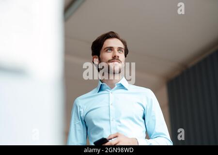 Thoughtful businessman standing in office Stock Photo