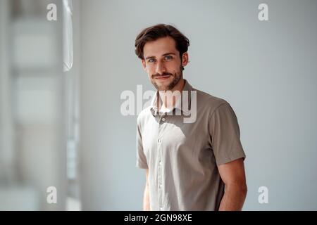 Smiling young man standing at home Stock Photo