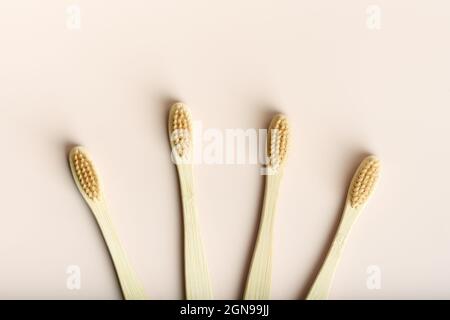 Flat lay with four eco friendly natural bamboo toothbrushes on pink background. Health care, copy space. Zero waste concept. Stock Photo