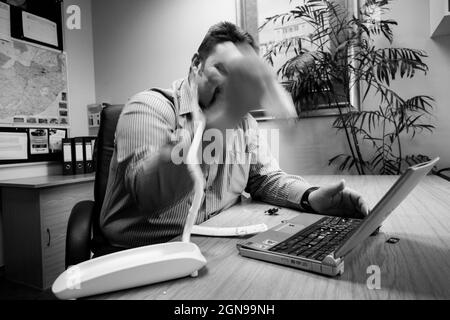 JOHANNESBURG, SOUTH AFRICA - Aug 09, 2021: An angry man frustrated with a broken laptop computer Stock Photo