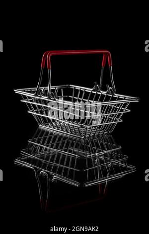 steel wire shopping basket for groceries isolated on a dark background with copy space. concept of black friday sales Stock Photo