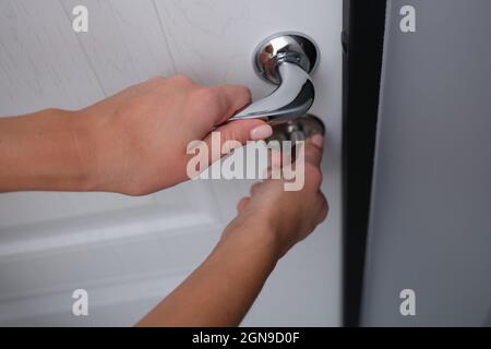 Door lock is opened by woman hand closeup Stock Photo