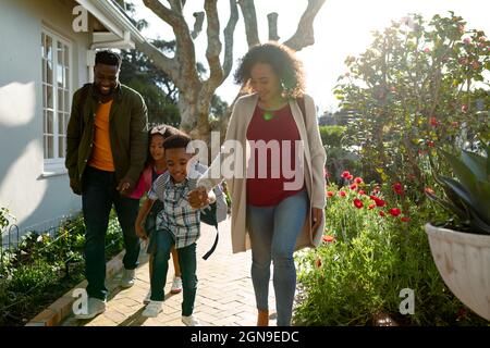 Happy african american family holding hands and walking outside Stock Photo