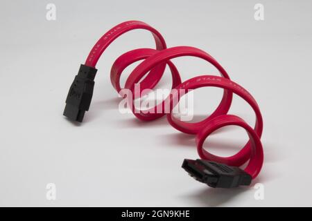 Red, black and orange SATA cable for connecting HDD or SSD to the computer. Motherboard connection cable to storage hardware. Data cable. Stock Photo