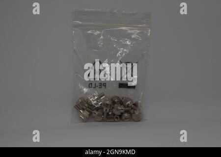 Screws in a small plastic bag. Pc screws. Computer screws together in a bag. Stock Photo