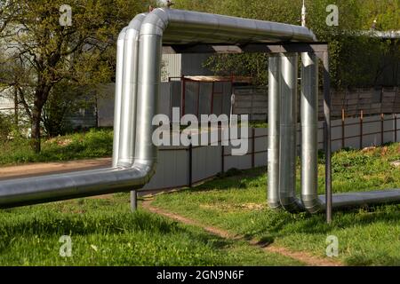 Heating pipes on the surface. Hot water supply. The heating main is covered with stainless steel. Stock Photo