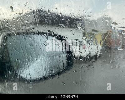 Raindrops on the car window on the background of the mirror Stock Photo