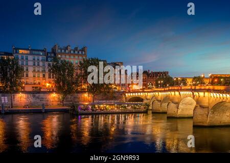 Paris, France - July 8, 2021: Pont Neuf bridge and Cite island over Seine river at night in Paris Stock Photo