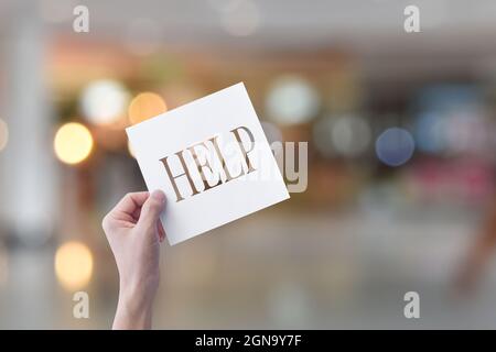 Hand hold paper with word help, on abstract bokeh background. Stock Photo