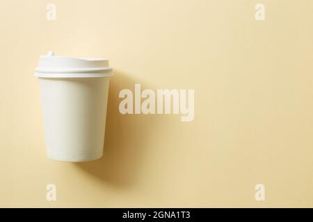 White paper coffee cup on beige background. top view, copy space Stock Photo