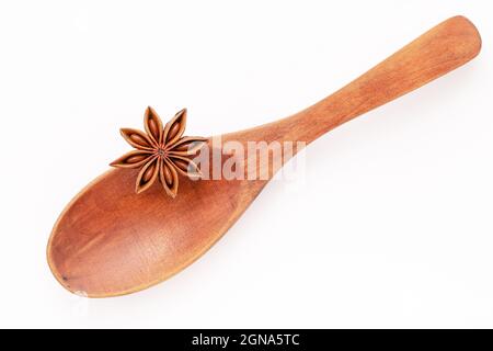 Close up chinese star anise in wooden spoon isolate on white background. Dried star anise spice fruits top view and copy space. Stock Photo