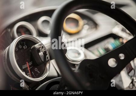 Rally car dashboard gauges and steering wheel close up macro, switches Stock Photo