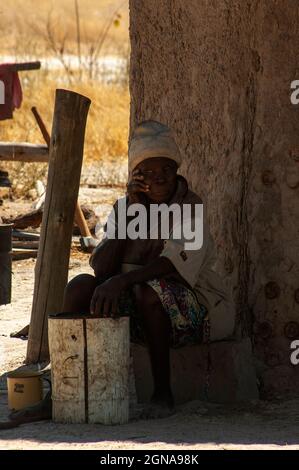 Old African woman in front of his house at Khwai Village between Moremi Reserve and Chobe Park, Botswana Stock Photo