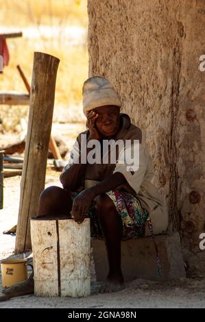 Old African woman in front of his house at Khwai Village between Moremi Reserve and Chobe Park, Botswana Stock Photo