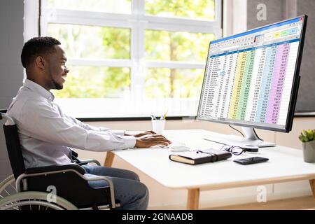 Medical Coding Spreadsheet On PC. African Man In Wheelchair Stock Photo