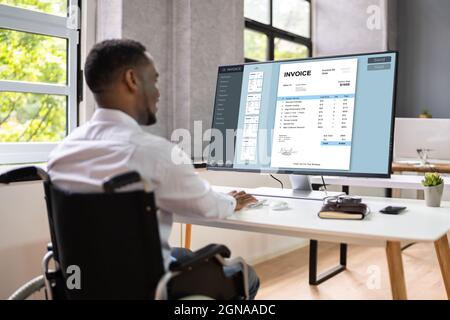 Disabled African Accountant Working On Computer In Wheelchair Stock Photo