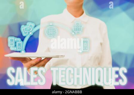 Hand writing sign Sales Techniques. Business overview methods that sales professionals use to create revenue Lady Uniform Standing Tablet Hand Stock Photo