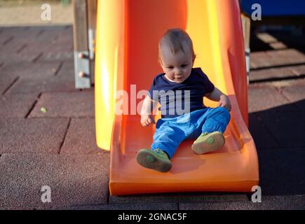 Cute little baby sitting on toboggan Stock Photo