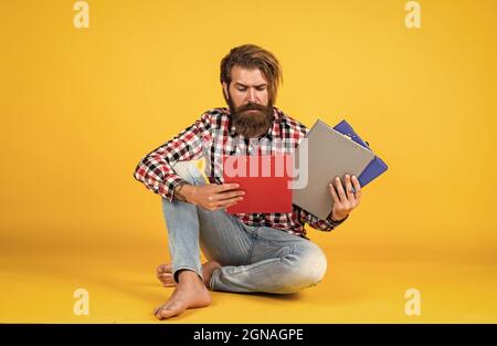 what should i do with this. casual styled man writing in document folder. paper work concept. typical office life. bearded man working with project Stock Photo