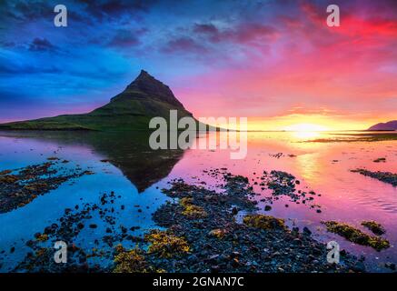 Colorful summer sunset with Kirkjufell mountain. Dramatic scene on Snaefellsnes peninsula with fall of tide in Atlantic ocean, Iceland, Europe. Stock Photo