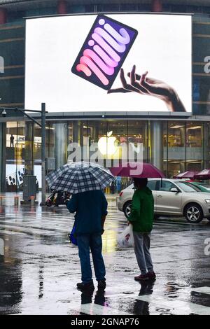 Beijing, China. 24th Sep, 2021. People walk in front of an iPad Mini advertisement on a large screen at an apple store in Wangfujing. On September 24, 2021, the first batch of iPhone 13 series mobile phones are officially launched to be sold worldwide. (Photo by Sheldon Cooper/SOPA Images/Sipa USA) Credit: Sipa USA/Alamy Live News Stock Photo