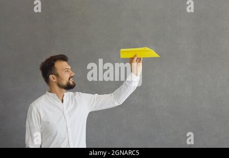 Businessman flying a paper airplane as a metaphor for aiming for business success Stock Photo