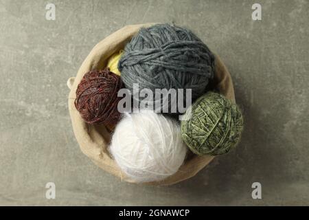 Wicker basket with yarn balls on light gray table Stock Photo