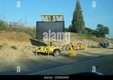 Road sign and road works on the M1 motorway Northamptonshire UK making a smart motorway led type frame screen stop sign grass verge fence fencing Stock Photo