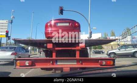 Driving on city behind a slow tow truck. View from the inside of the car Stock Photo