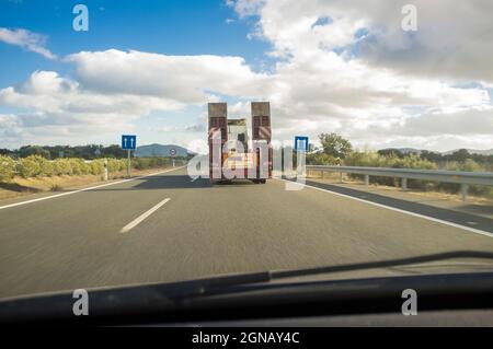 Heavy-duty truck with folded platform driving empty. View from the inside of the car Stock Photo